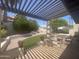Inviting covered patio with seating area overlooking the lush backyard with artificial turf at 9406 S 47Th Pl, Phoenix, AZ 85044