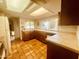 Bright kitchen featuring tile countertops, terracotta flooring, and abundant natural light from large windows at 9406 S 47Th Pl, Phoenix, AZ 85044