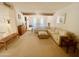 Open concept living room with neutral carpet, exposed beams, and comfortable seating arrangement at 9406 S 47Th Pl, Phoenix, AZ 85044