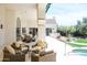 Relaxing back patio with wicker furniture, providing views of the lush backyard and pool at 10800 E Cactus Rd # 34, Scottsdale, AZ 85259