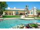 Backyard features pool, patio with covered area, and lush lawn surrounded by vibrant landscaping at 10800 E Cactus Rd # 34, Scottsdale, AZ 85259