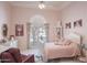 Pink bedroom with a white bed frame, ceiling fan, and a large window at 10800 E Cactus Rd # 34, Scottsdale, AZ 85259