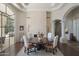 Bright dining room with elegant furnishings, featuring hardwood floors, fireplace and large windows overlooking outdoor lounge at 10800 E Cactus Rd # 34, Scottsdale, AZ 85259