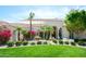 Charming front yard of this home with lush green lawn and pink bougainvillea bushes, enhancing curb appeal at 10800 E Cactus Rd # 34, Scottsdale, AZ 85259