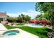 Lush backyard featuring a sparkling pool, spa, vibrant landscaping, and mature trees at 10800 E Cactus Rd # 34, Scottsdale, AZ 85259