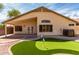 A beautiful outdoor putting green and landscaped backyard complements the covered patio and exterior of this lovely home at 12428 W Vermont Ct, Litchfield Park, AZ 85340