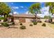 A sprawling front yard with mature trees and bushes complements the beautiful exterior elevation of this stunning property at 12428 W Vermont Ct, Litchfield Park, AZ 85340