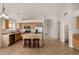 Bright eat-in kitchen featuring light wood cabinets, an island, and stainless steel appliances at 12428 W Vermont Ct, Litchfield Park, AZ 85340