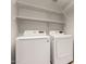 Laundry room equipped with a washer, dryer, and shelving for storage at 12428 W Vermont Ct, Litchfield Park, AZ 85340