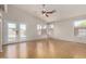Bright living room featuring hardwood floors, ceiling fan, and double doors leading to the backyard at 12428 W Vermont Ct, Litchfield Park, AZ 85340
