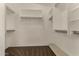 Walk-in closet with built-in shelving and hanging rods for ample storage at 12428 W Vermont Ct, Litchfield Park, AZ 85340
