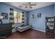 Bedroom with wood floors, a ceiling fan, and colorful decorations at 12503 W Vista Paseo Dr, Litchfield Park, AZ 85340