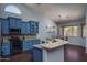 Modern kitchen featuring blue cabinets, stainless steel appliances, and granite countertops at 12503 W Vista Paseo Dr, Litchfield Park, AZ 85340