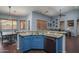 Open kitchen with blue cabinets and granite countertops connects seamlessly to the living area at 12503 W Vista Paseo Dr, Litchfield Park, AZ 85340