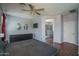 Well-lit main bedroom boasts wood floors, a ceiling fan, and an ensuite bathroom with a glass shower at 12503 W Vista Paseo Dr, Litchfield Park, AZ 85340