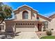 Inviting two-story home with a large, arched window, a three-car garage, and well-maintained landscaping at 13270 N 93Rd Way, Scottsdale, AZ 85260