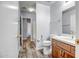 Bright bathroom with wood-look floors, a white vanity, toilet, and a door leading to another room at 13416 W Ventura St, Surprise, AZ 85379