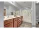 Bathroom features double sinks, updated shower, and wood-look flooring at 13416 W Ventura St, Surprise, AZ 85379