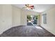 Bright bedroom offers a ceiling fan, neutral carpet, and sliding glass doors to the backyard at 13416 W Ventura St, Surprise, AZ 85379