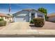 Charming single-story home features a two-car garage, light blue trim, and desert landscaping at 13416 W Ventura St, Surprise, AZ 85379