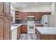 Well-lit kitchen featuring white appliances, dark wood cabinets, and granite countertops at 13416 W Ventura St, Surprise, AZ 85379