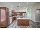 The kitchen features sleek, dark cabinets, stainless appliances, and a spacious island for prep at 13416 W Ventura St, Surprise, AZ 85379