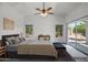 Serene main bedroom featuring soft carpet, vaulted ceilings, ceiling fan, and private outdoor access at 13416 W Ventura St, Surprise, AZ 85379