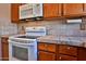 Traditional kitchen featuring an electric stove top, microwave and tiled countertops at 14235 N 26Th Dr, Phoenix, AZ 85023