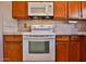 Traditional kitchen with white appliances and tiled backsplash at 14235 N 26Th Dr, Phoenix, AZ 85023