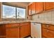 Well-lit kitchen sink area with tile countertops, wood cabinets, and a window view at 14235 N 26Th Dr, Phoenix, AZ 85023