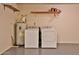 Clean laundry room featuring washer, dryer, and modern water heater, complete with durable flooring and overhead shelving at 14235 N 26Th Dr, Phoenix, AZ 85023