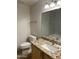Bathroom featuring wood cabinets, granite countertops, toilet and a mirror at 15225 N 100Th St # 1220, Scottsdale, AZ 85260