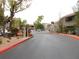 Gated community entrance with mature landscaping and a nicely paved road at 15225 N 100Th St # 1220, Scottsdale, AZ 85260