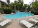 Upscale community pool with lounge chairs, waterfall feature, and lush landscaping at 15225 N 100Th St # 1220, Scottsdale, AZ 85260