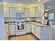 Bright kitchen featuring white cabinets, white appliances, and granite countertops at 15225 N 100Th St # 1220, Scottsdale, AZ 85260