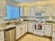 Galley kitchen boasts granite countertops, white cabinets, and stainless steel dishwasher at 15225 N 100Th St # 1220, Scottsdale, AZ 85260
