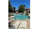 Community pool features clear, blue water, lounge chairs, and shade trees at 15225 N 100Th St # 1220, Scottsdale, AZ 85260