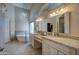 Bright bathroom featuring dual sinks, granite countertops, a soaking tub, a mosaic backsplash, and a chandelier at 15273 S 31St St, Phoenix, AZ 85048