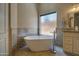 Bathroom featuring a soaking tub with tile surround, a window, and a vanity with granite countertops at 15273 S 31St St, Phoenix, AZ 85048