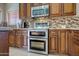 Gourmet kitchen with custom cabinetry, granite counters, double ovens and stainless steel appliances at 15273 S 31St St, Phoenix, AZ 85048