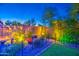 Night view of a backyard featuring a well-manicured artificial grass, decorative plants, and illuminated landscape at 16042 W Shaw Butte Dr, Surprise, AZ 85379