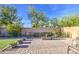 Landscaped backyard features a large brick patio, lush trees, and a decorative metal fence at 16042 W Shaw Butte Dr, Surprise, AZ 85379