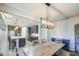 The dining area has a rustic table set, elegant light fixture, and flows into the kitchen and living areas at 16042 W Shaw Butte Dr, Surprise, AZ 85379