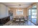The dining area has a rustic table set, elegant light fixture and a sliding door for natural light and outdoor access at 16042 W Shaw Butte Dr, Surprise, AZ 85379