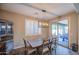 The dining area features a rustic table and chairs, plantation shutters on the window and access to outdoor living space at 16042 W Shaw Butte Dr, Surprise, AZ 85379