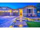 Stunning curb appeal with a brick pathway, ambient lighting, and charming front porch at 16042 W Shaw Butte Dr, Surprise, AZ 85379