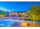 Well-lit home exterior showcasing a three-car garage and inviting front entrance at 16042 W Shaw Butte Dr, Surprise, AZ 85379