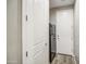 Hallway view of a black refrigerator, white doors and wood-style floors at 16042 W Shaw Butte Dr, Surprise, AZ 85379
