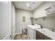 Functional laundry room equipped with modern washer/dryer and utility sink at 16042 W Shaw Butte Dr, Surprise, AZ 85379