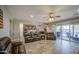 Open-concept living area with leather seating, ceiling fan, outdoor access and views into the kitchen at 16042 W Shaw Butte Dr, Surprise, AZ 85379